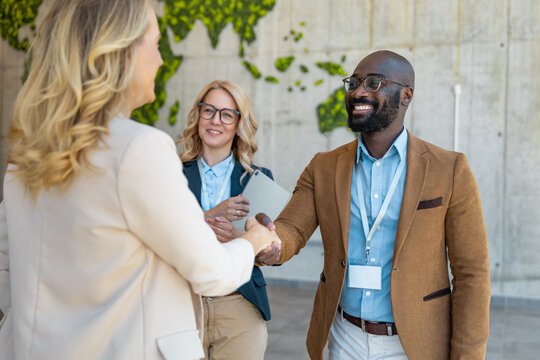 Handshake at an office meeting between colleagues in a city with a greenery wall