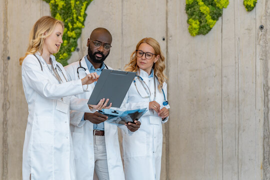 Medical team discusses patient care in modern facility with green wall accents