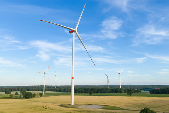 Offshore wind park. Wind turbines farm. Alternative renewable energy generation. Green energy concept. Organic harvest in farm field. Agricultural harvest. Crop cultivation. Wind turbines farm