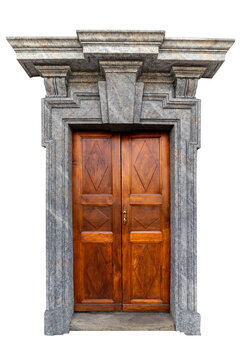 Antique wooden double door with diamond carvings, framed by majestic Baroque style grey stone portal with ornate moldings and central keystone, isolated on white clipping path for architecture design