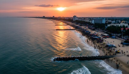 Obraz premium High angle view of busy rk beach at sunset in visakhapatnam with crowds along the coastline for a coastal tourism concept with golden light over ocean waves