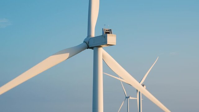 Close-Up of Wind Turbine Nacelle and Blades Against Blue Sky
