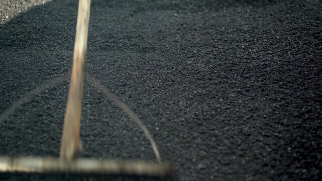 Manual Asphalt Surface Leveling With a Road Rake