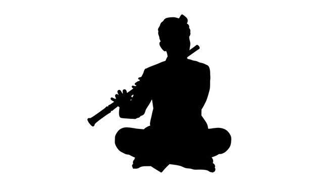 Silhouette of a musician playing a flute while sitting