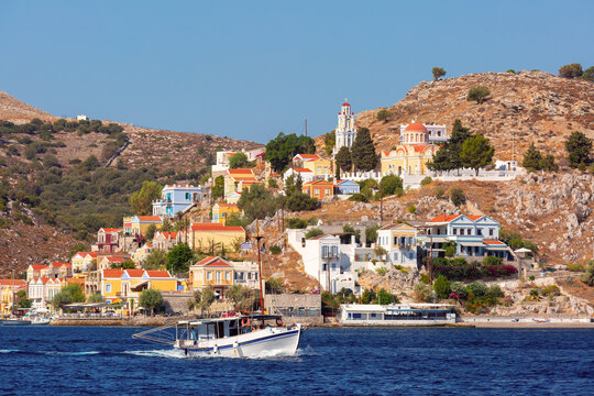 Fishing Boat on Symi Harbor with Hillside Architecture and Church, Greece