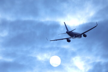 Fototapeta premium 太陽に向かって飛ぶ旅客機のシルエット