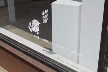 Fototapeta premium vinyl window signs at Cry Baby Gallery, a hidden speakeasy cocktail and oyster bar located behind an active art gallery at 1468 Dundas St W, Toronto