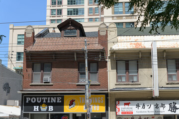 Fototapeta premium exterior building facades and signs of Poutine Hub (132 Dundas St E) and Gyukatsu Kyoto Katsugyu (134 Dundas St E), Toronto