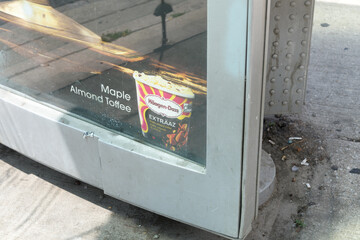 Fototapeta premium OOH advertising poster at a grungy bus shelter for Häagen-Dazs EXTRÄAZ Maple Almond Toffee Ice Cream, Toronto