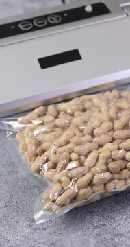 Vacuum-sealed peanuts on a kitchen counter for meal prep,and preservation. Homemade kitchen concept. Vertical video	