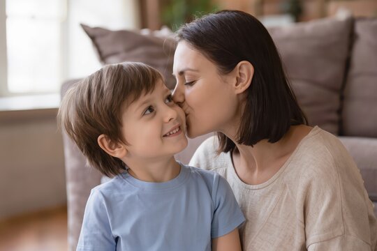 M&egrave;re c&acirc;linant son b&eacute;b&eacute; ou embrassant son jeune enfant &agrave; la maison, portrait familial illustrant l'amour maternel, la tendresse et le lien parent-enfant
