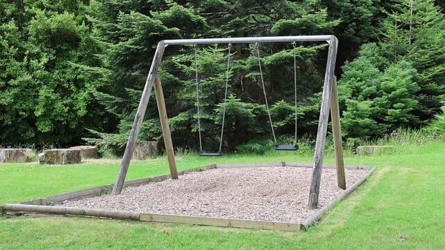 Empty Swing Set Gently Swaying at a Playground