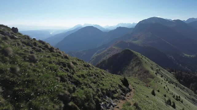 Aerial drone panorama of Mount Golica during spring with blooming wild daffodils, green alpine meadows, forested hills and breathtaking views across the Slovenian landscape.
