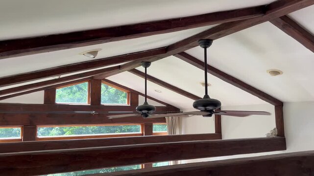 ceiling fans spinning on wooden beam vaulted ceiling