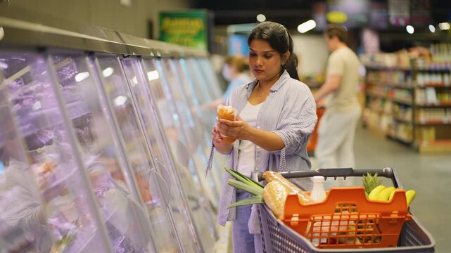 Indian woman choosing frozen food at supermarket