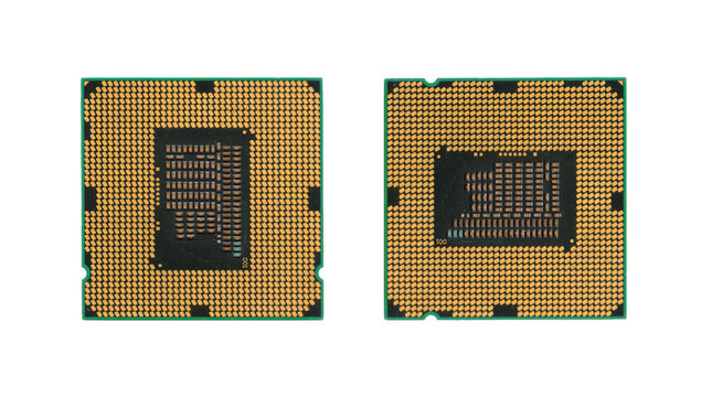 Two computer CPU microprocessors showing gold contacts isolated on black