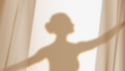 Silhouette, shadow on the wall of a graceful ballerina dancing behind curtains. © Lidiia Shapoval