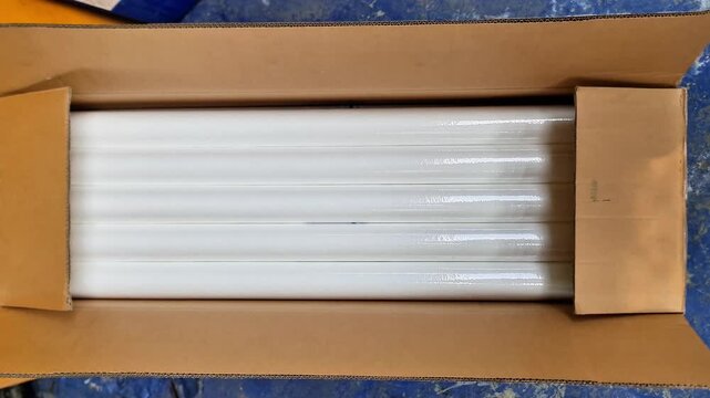 Top view of bulk white spun polypropylene sediment water filter cartridges inside a cardboard box for industrial reverse osmosis purification systems.