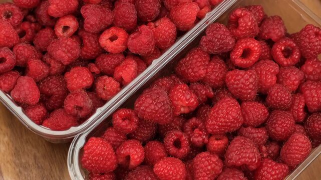 Fresh raspberries in plastic boxes in the supermarket