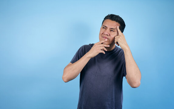 portrait of Latin man with expression of thought on blue background in Mexico Latin America