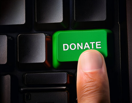 Hand presses "Donate" button on dark keyboard