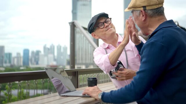 Senior gay couple using digital devices at a city viewpoint, planning their trip and sharing travel experiences during an active retirement journey