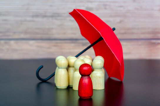 Close up of leadership figure under umbrella providing protection, trust, and insurance safety for a team of followers.