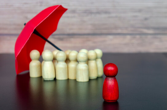 Focus view of leadership figure surrounded by followers under umbrella representing trust, security, and collective protection.