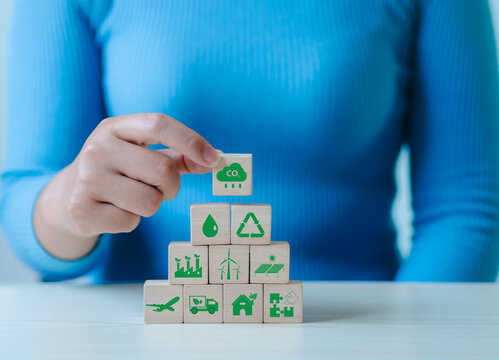 Businesspeople display icons for carbon dioxide reduction, recycling, and a green environment; responsible green business and sustainable environmental development.