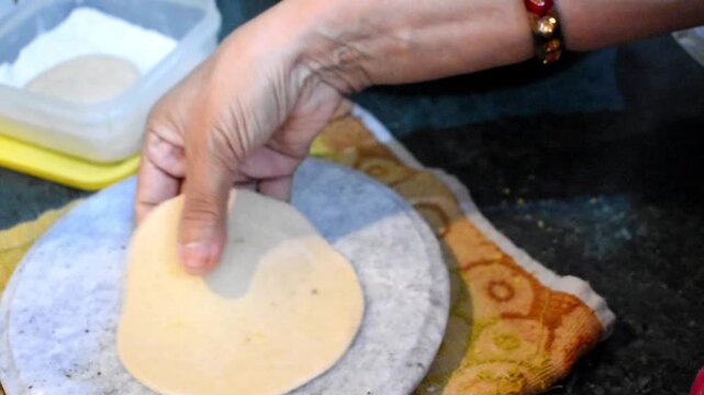 preparing stuffed dal paratha by filling wheat dough with seasoned lentil stuffing