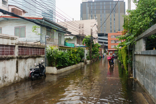 Delivery scooter on flooded street during rainy season  