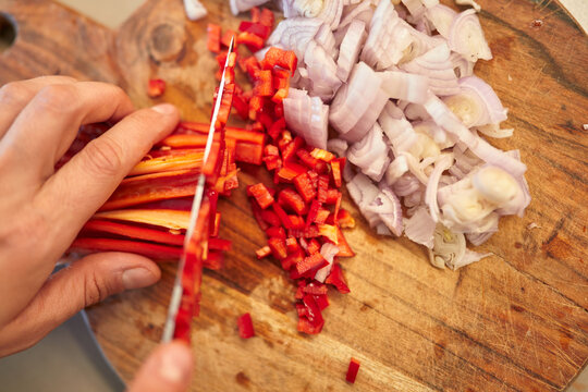 Chef Chopping Fresh Red Peppers and Onions
