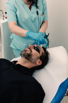 Derm applies topical to patient in shields in modern clinical setting.