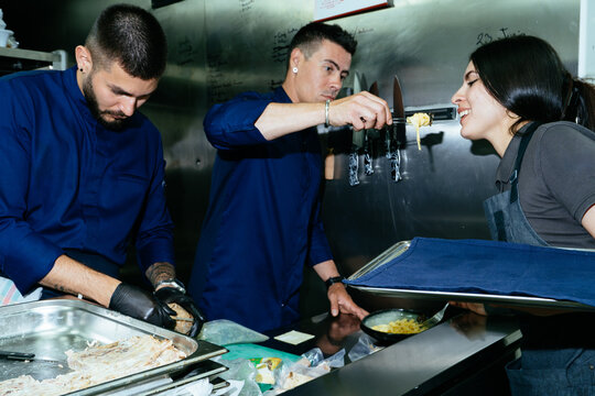Restaurant chefs working and tasting food in kitchen