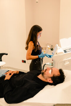 Dermatologist examines a man's facial skin with a magnifier