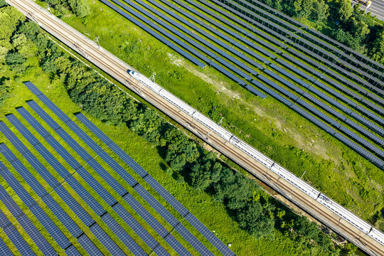 Aerial view of high speed rail beside solar panels