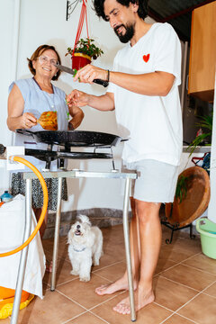 Family generations cooking traditional meal together at home