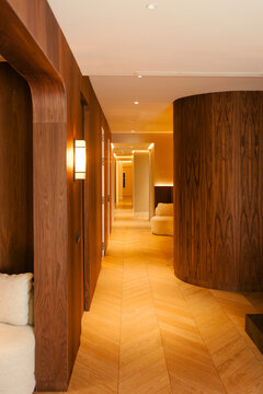 Modern clinic with wood walls, herringbone floors, and lit hallway.