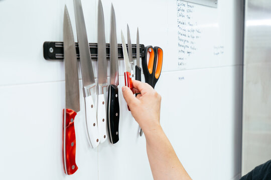 Chef's hand picking knife from magnetic rack