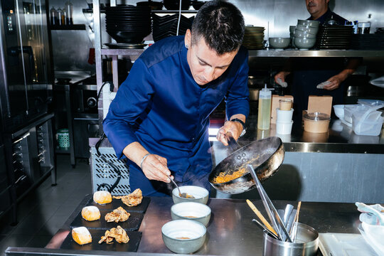 Chef plating gourmet dish in commercial kitchen