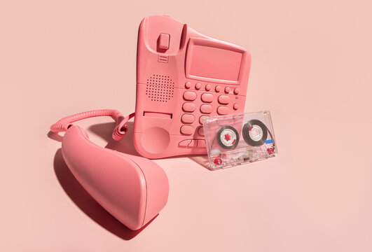 Still life with Old Style Telephone and Cassette Tape on Pink Backdrop