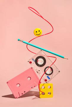 Still life with Cassette Tape, Pencil and Smiley Face on Pink Backdrop