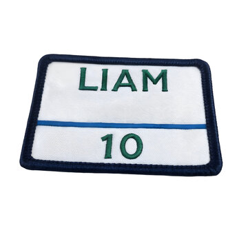 A rectangular name and number badge with white fabric and dark blue trim is displayed