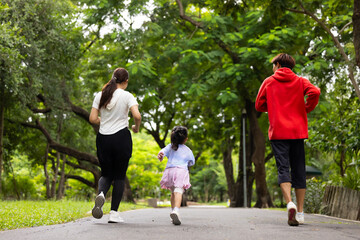 Obraz premium Backview Family exercising and jogging together in city park summer. healthy lifestyle in nature. Father mother, kids daughter exercise. Family team, children. healthy lifestyle and family bonding