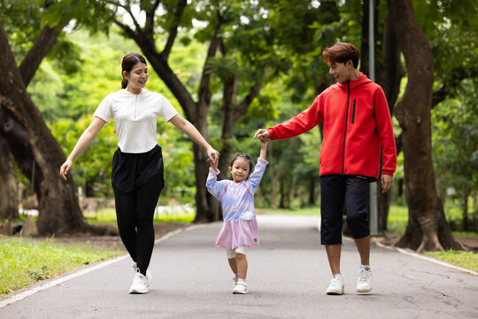 Family exercising and walking together in city park summer. healthy lifestyle in nature. Father mother, kids daughter exercise. Family team, children. healthy lifestyle and family bonding