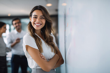 Fototapeta premium Portrait of happy smiling confident young very attractive businesswoman CEO professional manager entrepreneur in a skirt presenting at a business meeting in front of a whiteboard looking at camera