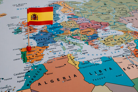 Close-up of a map of Europe with a Spanish flag pin stuck in Spain, conceptualizing European borders, geopolitics, and current migration crisis.