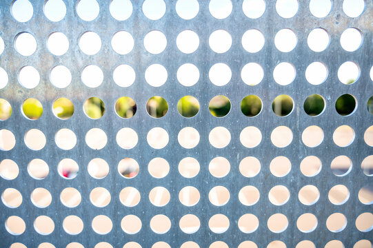 Perforated metal panel with circular holes abstract background