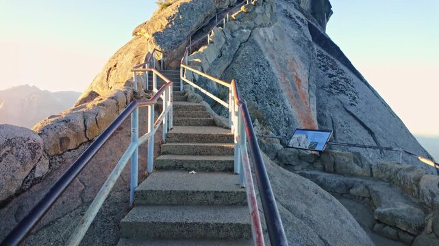 Golden sunrise light glows over the winding stairs to Moro Rock in Sequoia National Park