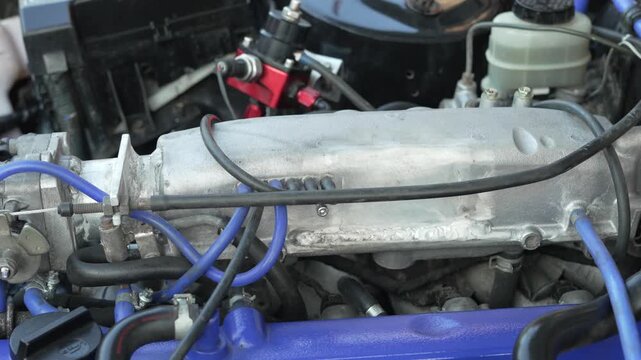 Close-up of custom intake manifold and throttle body in engine bay.